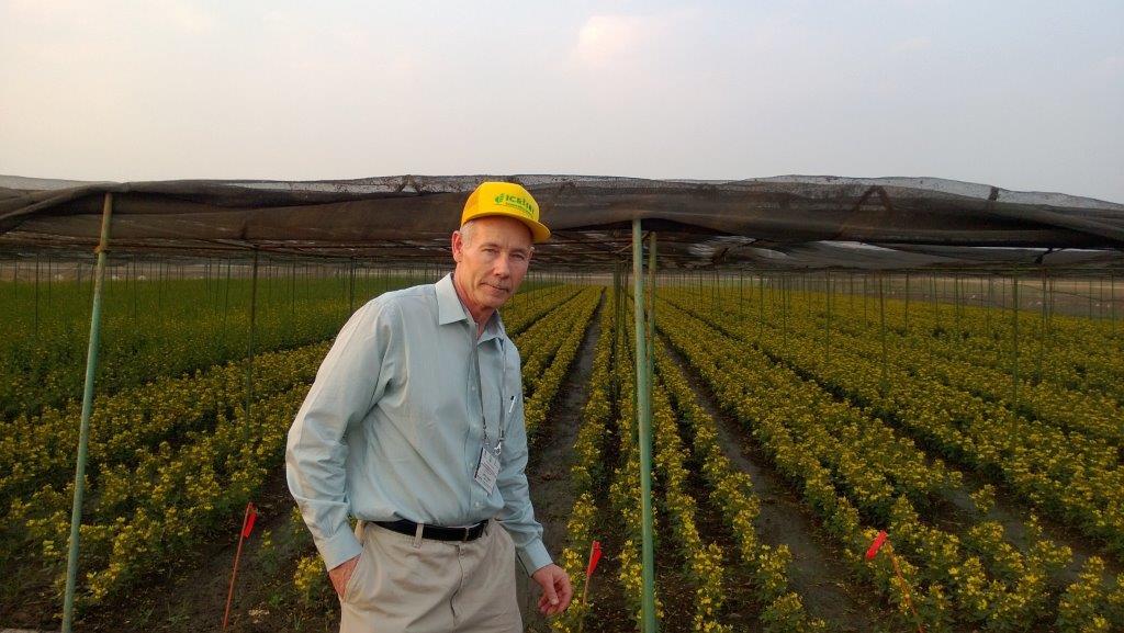 February 2014: Jeff donning his new Gates hat (albeit with a literal ICRISAT cap on). Behind him is a field of early maturing pigeonpea experiment at ICRISAT India. 